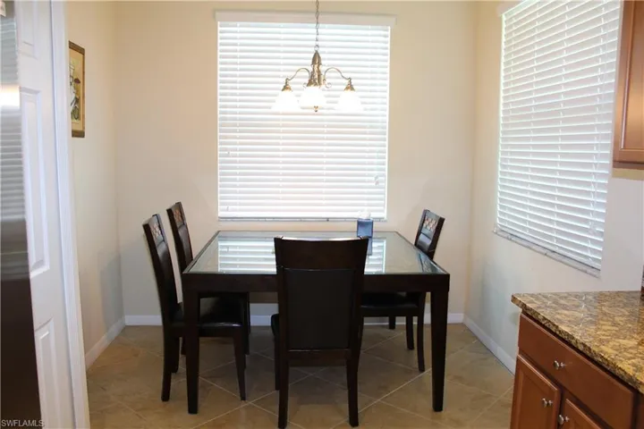 Dining space with light tile patterned flooring, plenty of natural light, and a chandelier