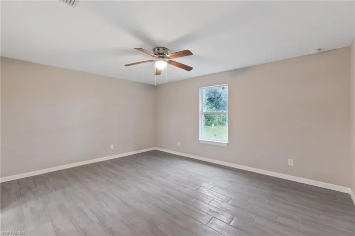Spare room with hardwood / wood-style flooring and ceiling fan