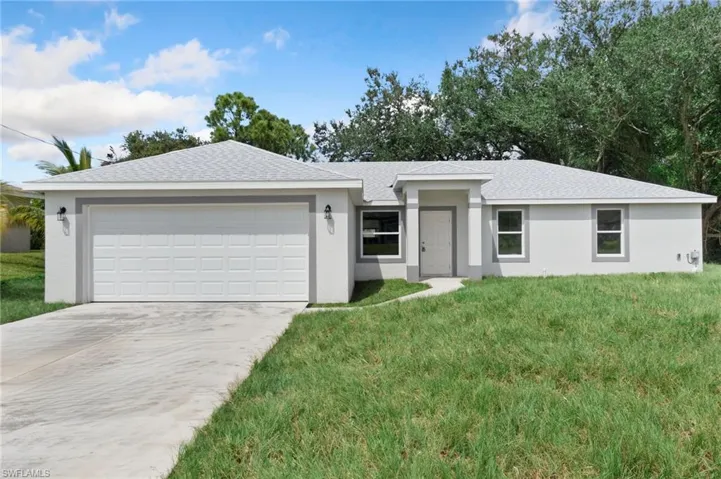 Ranch-style house with a front yard and a garage