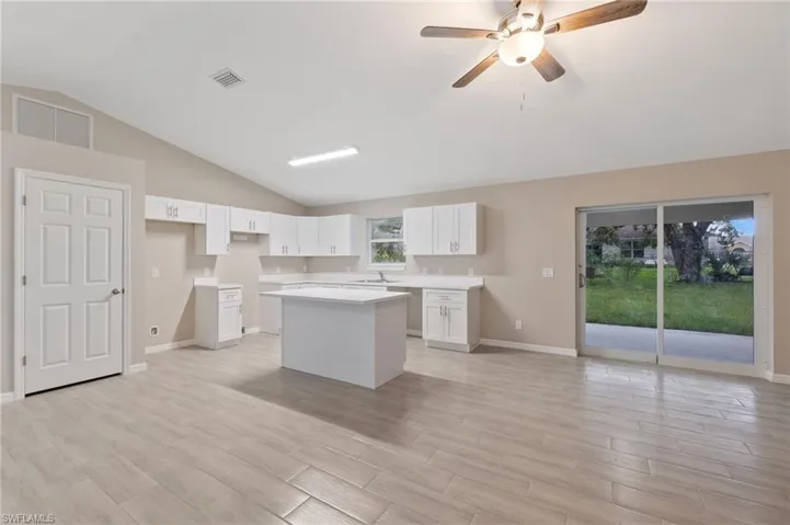 Kitchen featuring a healthy amount of sunlight, a center island, and white cabinets