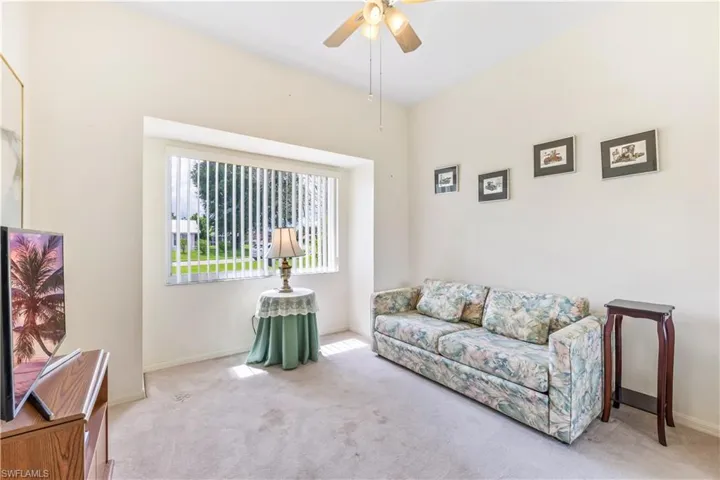 Carpeted lroom with ceiling fan