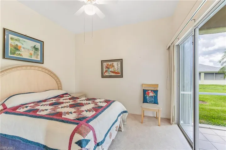 Carpeted bedroom featuring ceiling fan and access to exterior