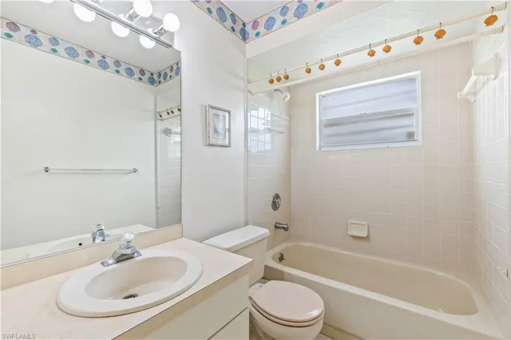 Full bathroom with tiled shower / bath, toilet, and vanity