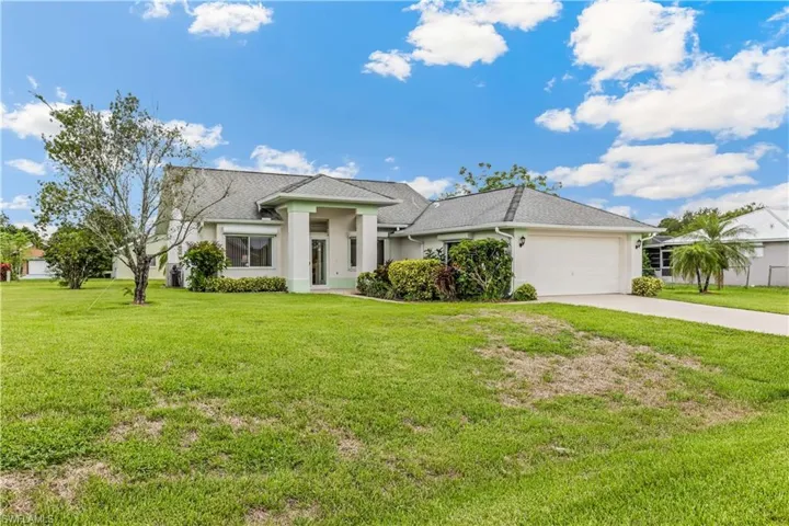 View of front of home with a garage and a front yard