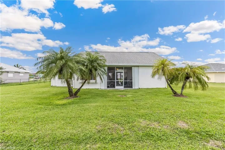 Rear view of property with a yard
