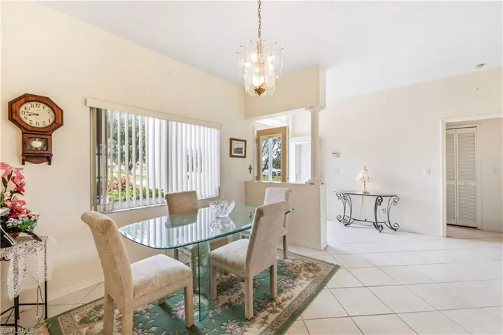 Tiled dining room with a healthy amount of sunlight and a notable chandelier