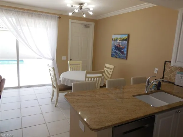 Dining area featuring crown molding, a chandelier, and light tile patterned floors