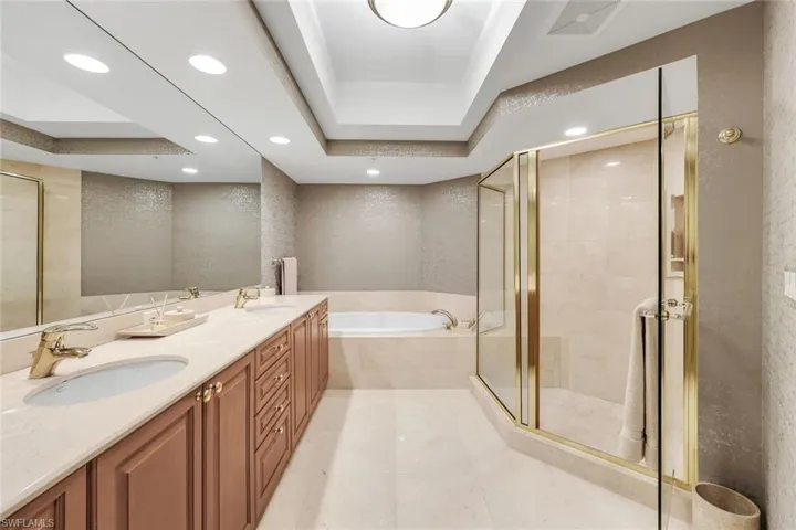 Primary bathroom featuring a large soaking tub, walk-in shower, and soft lighting for a spa-like feel.