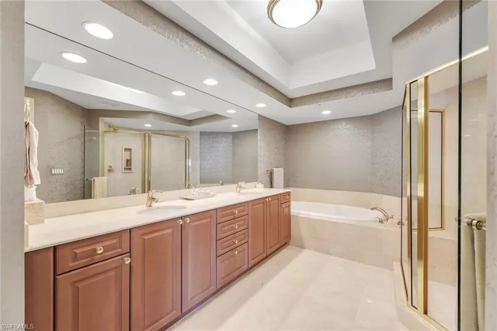 Generous ensuite with dual sinks, warm finishes, and abundant counter space.