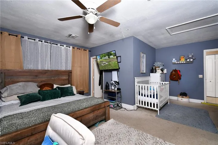 Converted Attached Garage: Room featuring a ceiling fan with integrated lighting, textured ceilings, and wall-to-wall carpeting