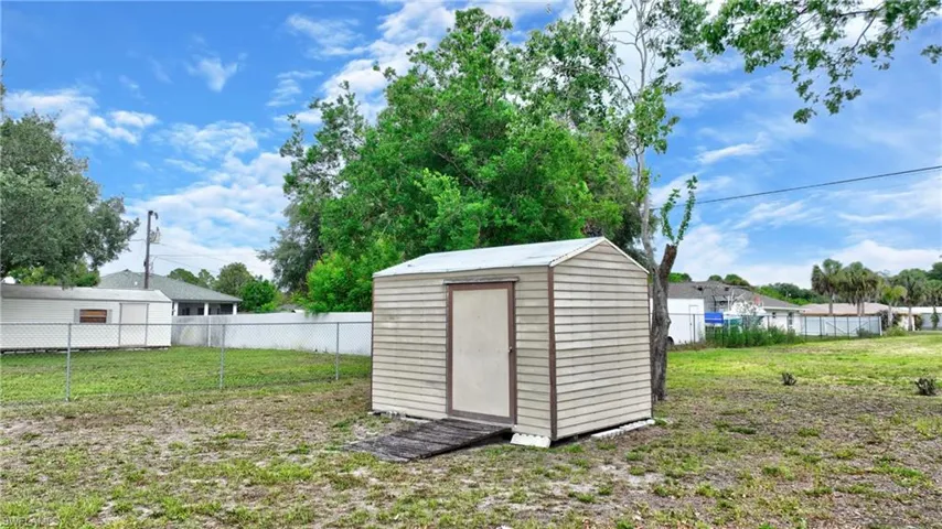 Exterior storage shed with horizontal siding and a single door entrance, positioned on a grassy area