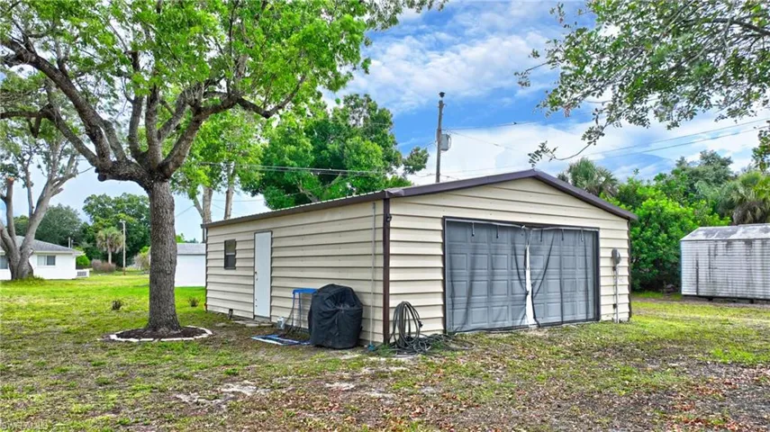 Detached garage structure with horizontal siding and a dual-door entry with AC