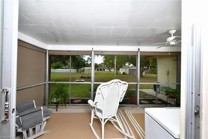 Screened porch featuring a ceiling fan, light-colored flooring, and expansive exterior views
