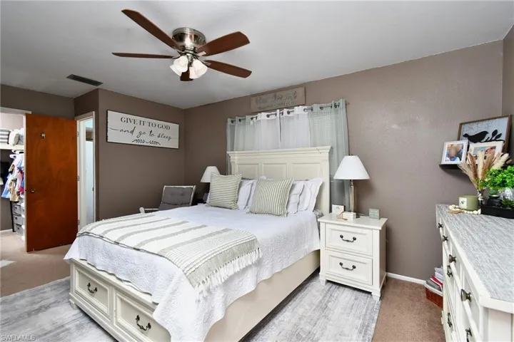 Primary Bedroom featuring a ceiling fan with integrated lighting, neutral wall paint, and carpet flooring