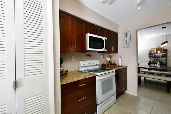 Kitchen featuring dark wood cabinetry, granite-style countertops, and a built-in microwave