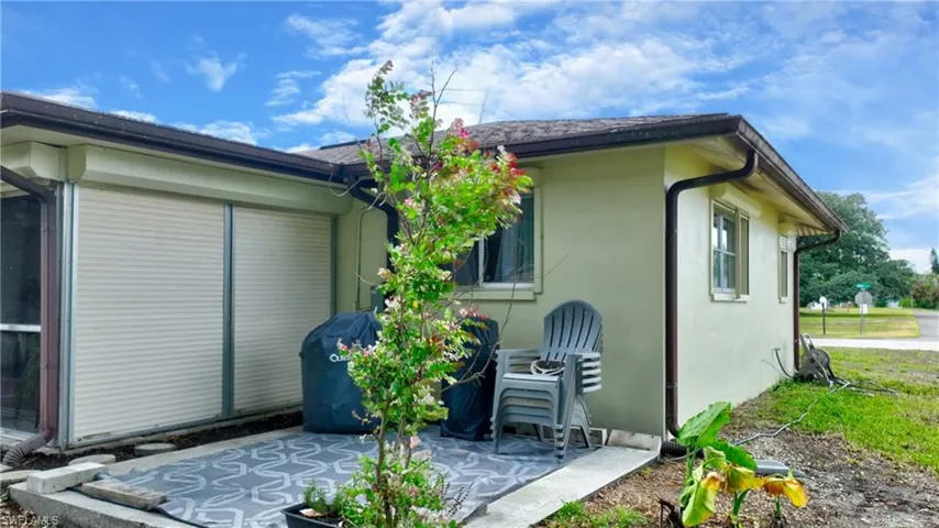 Exterior patio featuring roll-down hurricane shutters and a light-colored stucco finish