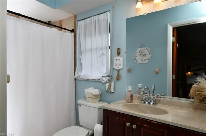 Primary Bathroom featuring a dark wood vanity with a light-colored countertop, an integrated sink, and a chrome faucet