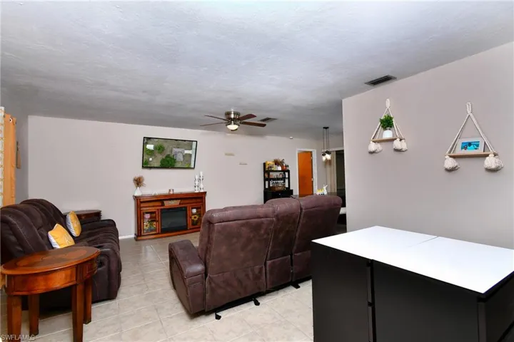 Spacious living area featuring light-toned tile flooring throughout and neutral wall paint