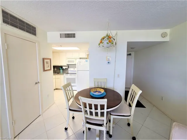 Dining room featuring light tile patterned flooring and a textured ceiling