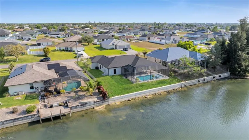Aerial view of residential area featuring a nearby body of water