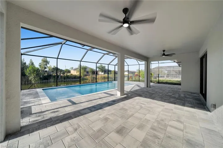 Outdoor pool featuring a ceiling fan, a patio area, and a lanai