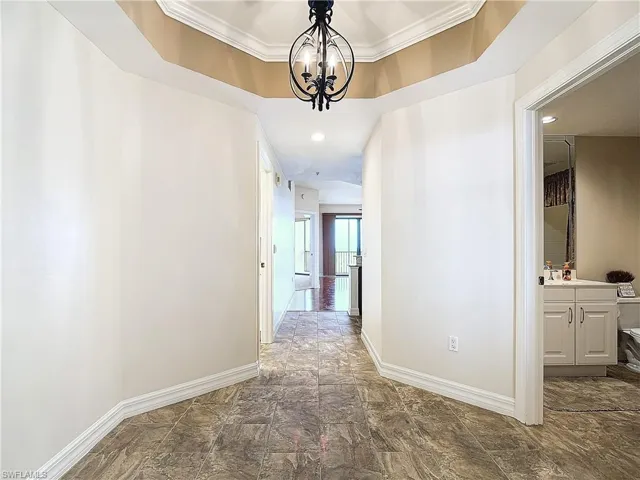 Hall featuring a chandelier and crown molding