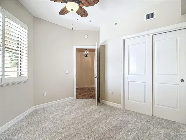 Unfurnished bedroom featuring ceiling fan, light colored carpet, and a closet