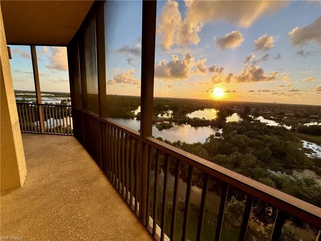 Balcony at dusk featuring a water view