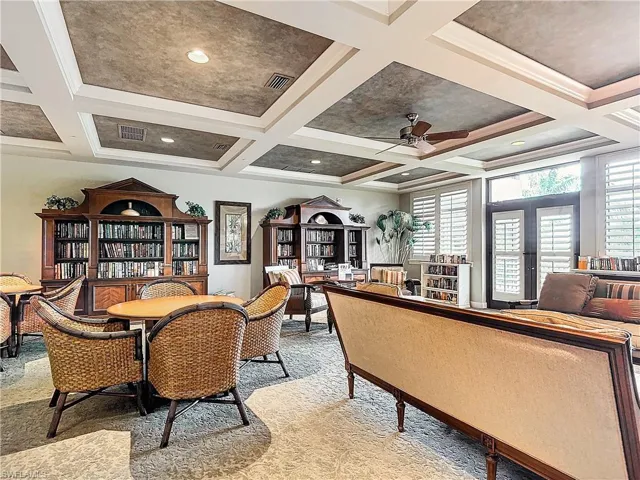 Carpeted dining space with coffered ceiling, ceiling fan, french doors, crown molding, and beam ceiling