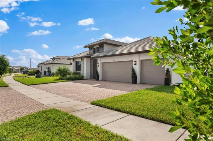 View of front of house with a garage and a front lawn
