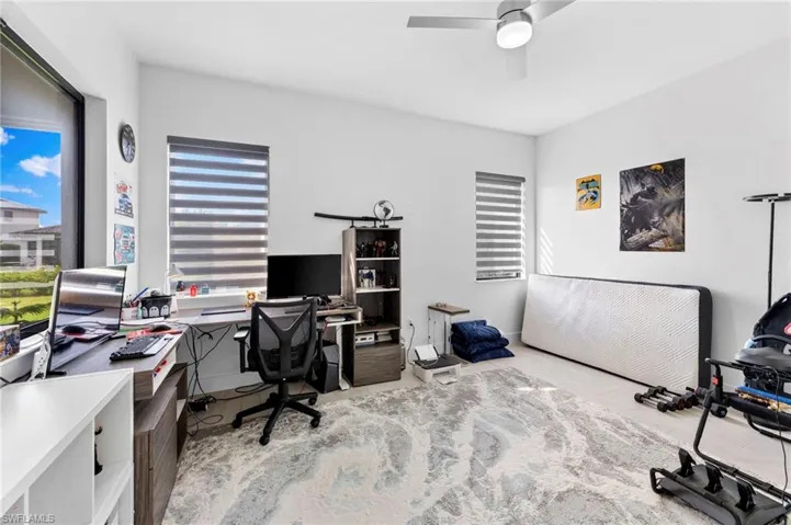 Home office with ceiling fan and light hardwood / wood-style floors