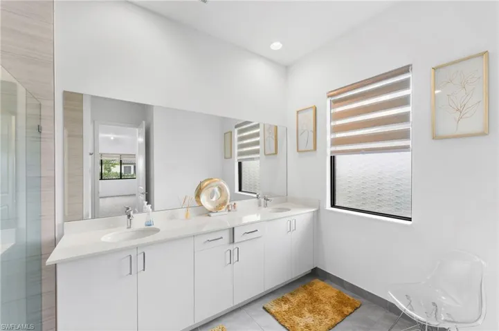 Bathroom with tile patterned flooring, vanity, and a shower with door