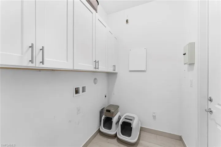 Laundry area featuring washer hookup, light hardwood / wood-style flooring, cabinets, and hookup for an electric dryer