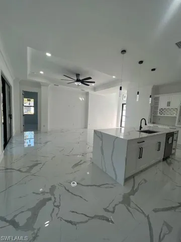 Kitchen featuring white cabinetry, light stone counters, light marble finish flooring, a ceiling fan, and recessed lighting
