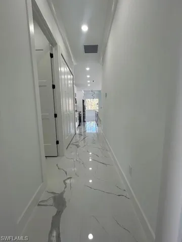 Corridor with recessed lighting and light marble finish flooring