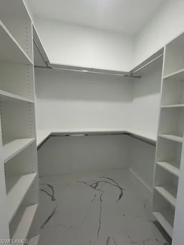 Spacious closet featuring marble look tiles