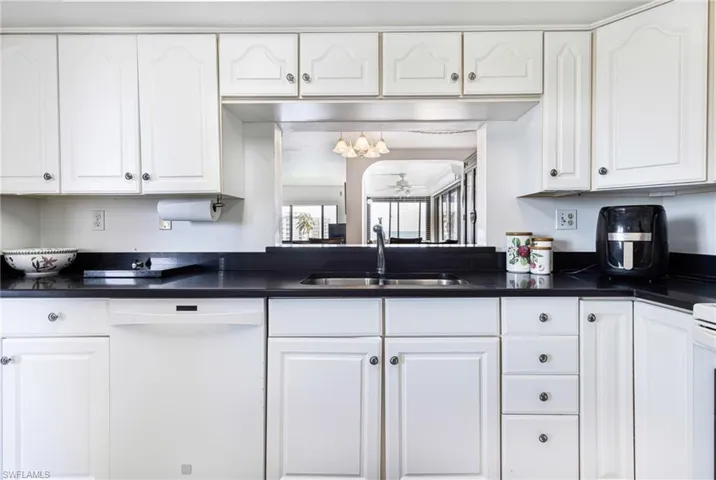 Kitchen with white cabinets, dishwasher, and sink