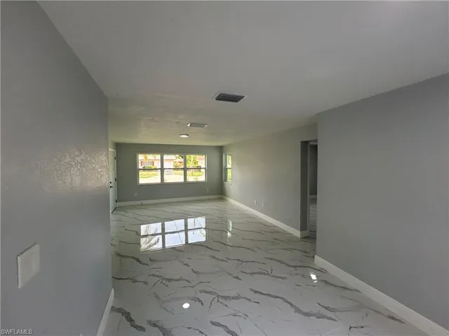 Unfurnished room with baseboards and marble finish flooring
