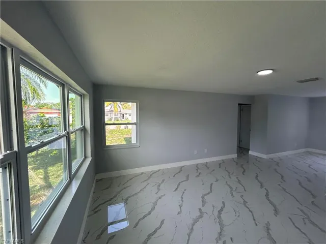 Unfurnished room with baseboards, light marble finish floors, and recessed lighting