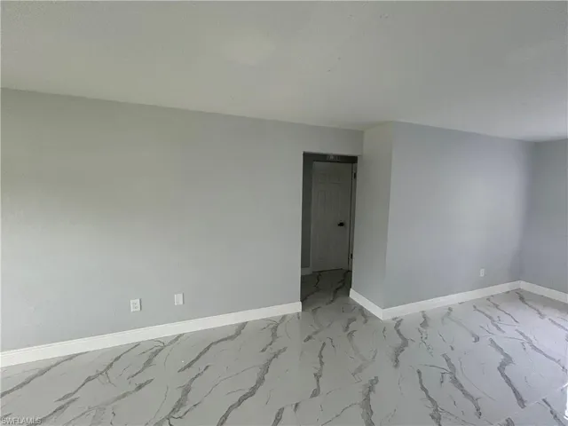 Spare room with baseboards and light marble finish floors