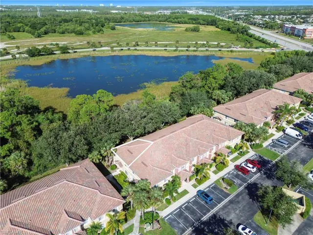 Aerial view of residential area with a tree filled landscape and a nearby body of water