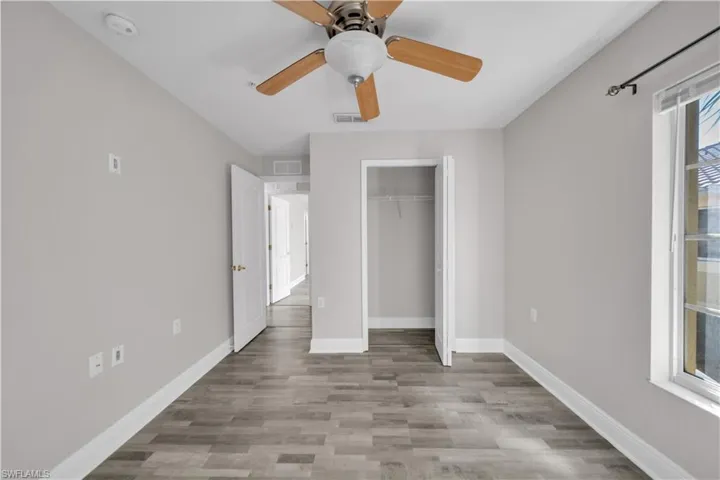 Unfurnished bedroom featuring ceiling fan, a closet, and light wood-style flooring