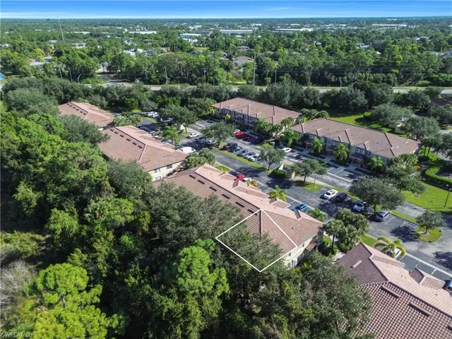 Aerial view of property and surrounding area featuring property boundaries highlighted and nearby suburban area
