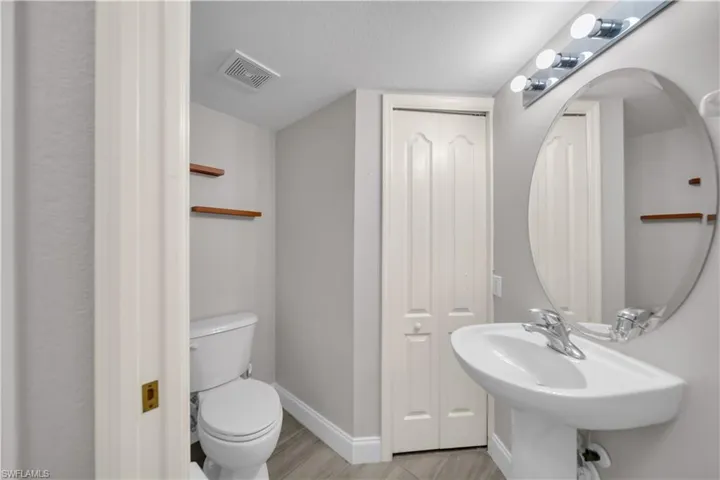 Bathroom featuring a textured ceiling, a closet, and light wood-style flooring