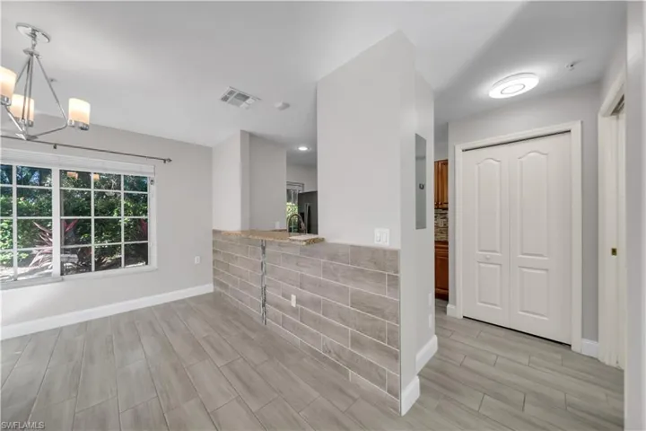 Foyer entrance featuring wood finish floors and a chandelier