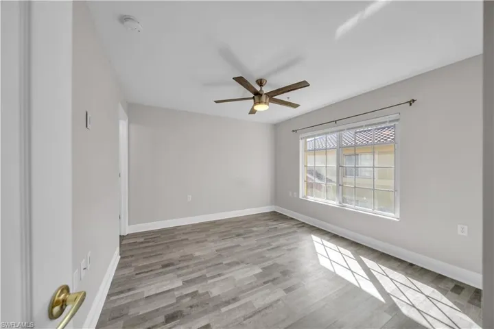 Empty room featuring light wood-type flooring and a ceiling fan