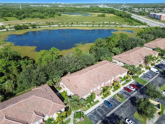 Aerial perspective of suburban area featuring a tree filled landscape and a large body of water