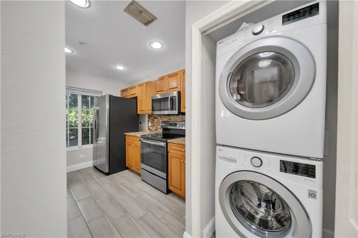 Washroom featuring stacked washer and clothes dryer, recessed lighting, wood tiled floors, and a textured wall
