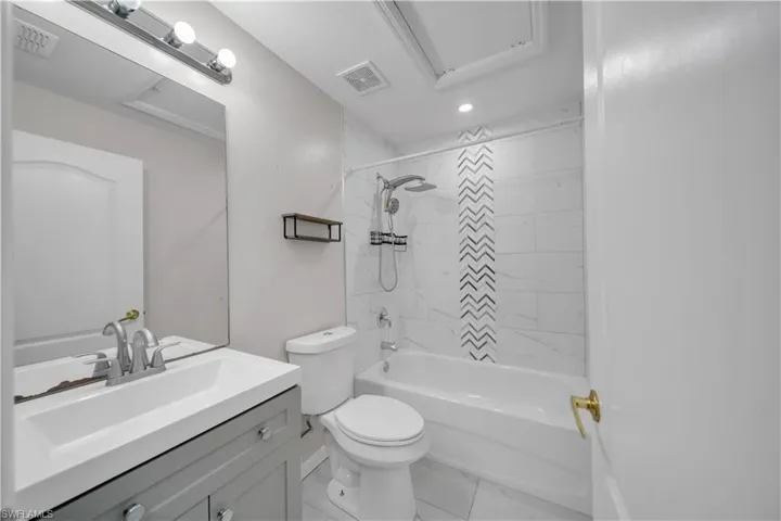 Bathroom with vanity,  shower combination, and recessed lighting