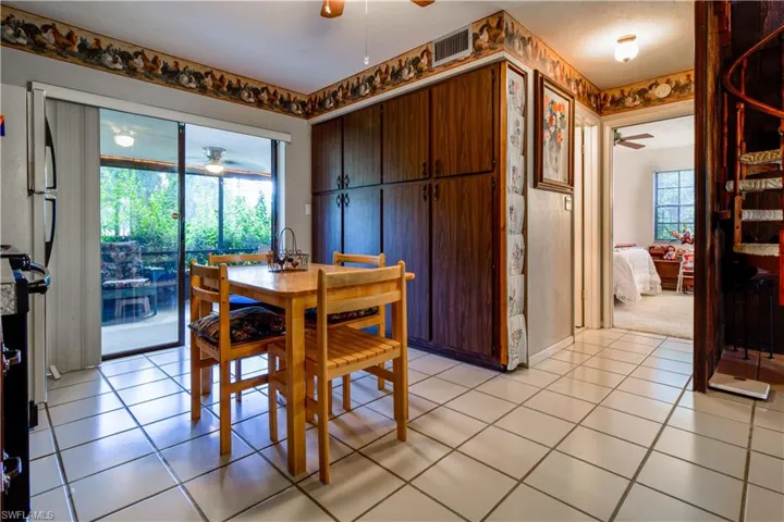 Warm And Homey Kitchen With Tiled Floors, A Wall Of Pantry Storage Cabinetry, Sliders To The Huge Screened Lanai. Also Private Entrance to the 1st Floor Bedroom And Bathroom. Finally, A Glimpse Of The Circular Staircase.